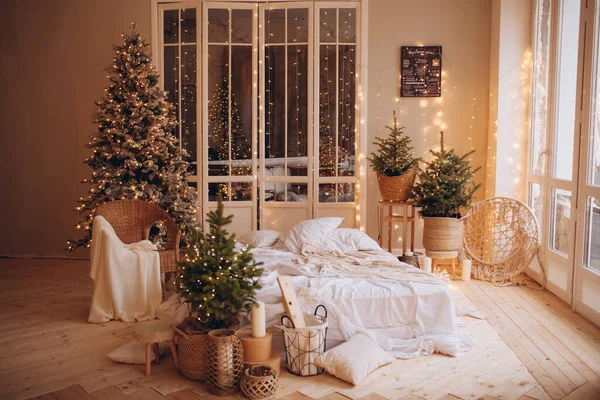 cozy light room with a mattress bed in Christmas style design and xmas tree