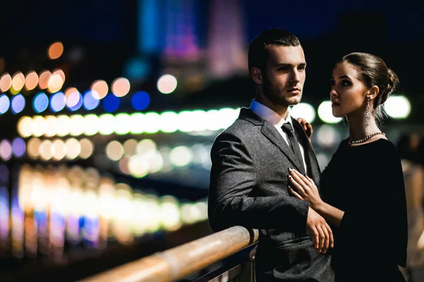 穿着时髦服装的年轻夫妇晚上在外面拥抱 — 图库照片