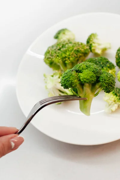 Brokoli Hijau Segar Pada Piring Putih Tangan Perempuan Dengan Garpu — Stok Foto