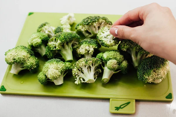 Tangan Wanita Mengambil Brokoli Hijau Segar Dari Pemotongan Papan — Stok Foto