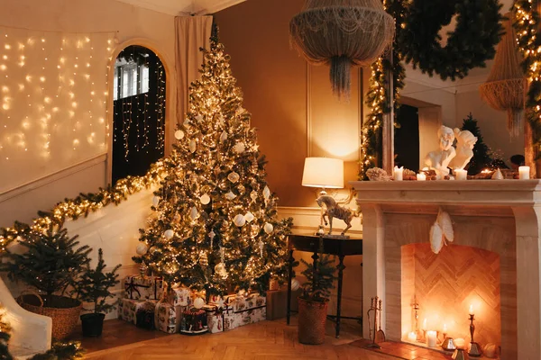 Noel odasının iç tasarımında lüks ve sıcak bir akşam, ışıklarla süslenmiş Xmas ağacı hediyeler, mumlar, fenerler, şömineler. Tatil salonu. Yeni yıl tatili