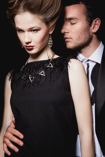 Güzel, tutkulu bir çift koridorda dikiliyor, bir adam bir kadına arkadan sarılıyor.