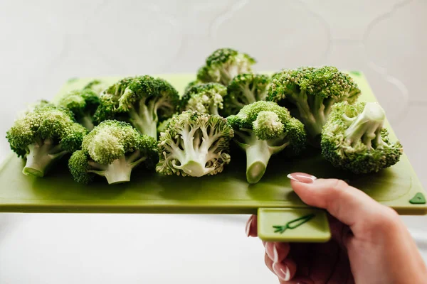 Tabla Cortar Mano Femenina Con Brócoli Fresco Verde —  Fotos de Stock