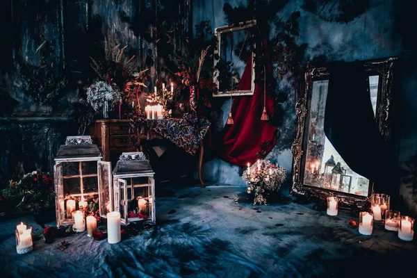 Kurumuş çiçekler, vazolar, avizeler, altın çerçeveli kumaşlar, lüks kraliyet tarzı ahşap bir masa, eski fenerlerle yanan mumlar.