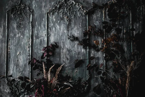 Kurumuş çiçekler, vazolar, avizeler, altın çerçeveli kumaşlar, lüks kraliyet tarzı ahşap bir masa, eski fenerlerle yanan mumlar.