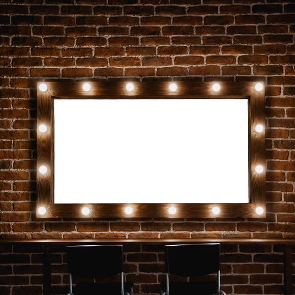 wooden dressing mirror with light bulbs on brick wall background