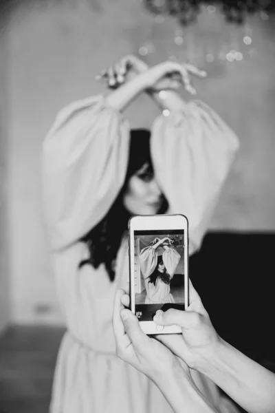 女性の手で写真を撮るビデオバックステージ携帯電話で美しいモデルを撮影カラフルな背景テキスト — ストック写真