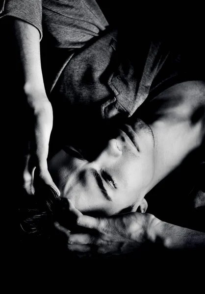 Yerde siyah saçlı, gri ceketli ve tişörtlü yakışıklı bir erkek modelin portresi var.