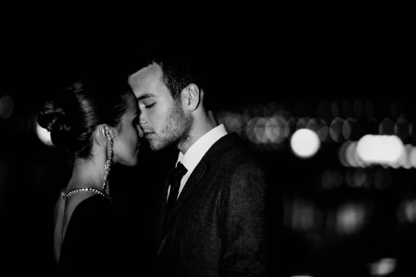 穿着时髦服装的年轻夫妇晚上在外面拥抱 — 图库照片