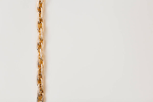 closeup view of massive golden braided chain bracelet on a white background