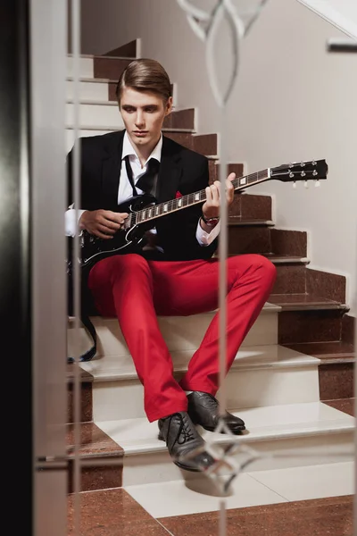 Handsome Man Red Trousers Black Jacket Sitting Stairs Playing Guitar — Stock Photo, Image