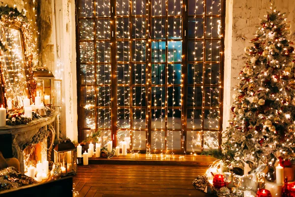 豪華な古いクリスマスルームで暖かい居心地の良い魔法の夜おとぎ話のインテリアデザイン ギフト キャンドル ランタン ガーランド照明で飾られた火の場所クリスマスツリー — ストック写真