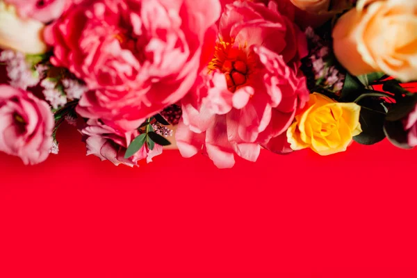 Kırmızı arka planda renkli çiçekleri olan güzel bir buket.