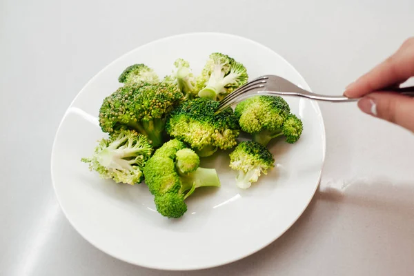 Groene Verse Broccoli Een Witte Plaat Vrouwelijke Hand Met Een — Stockfoto