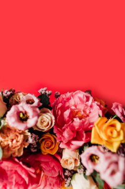 Kırmızı arka planda renkli çiçekleri olan güzel bir buket.