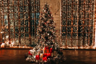 Lüks eski Noel odası peri masalı iç tasarımı, pahoramik pencereler, şömine ağacı ışıklar, hediyeler, mumlar, fenerler, çelenkler ile süslenmiş.