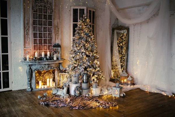 Noel odasında sıcak ve sıcak bir akşam, iç tasarım, ışıklarla süslenmiş Noel ağacı, oturma odası. Yeni yılda sihir.