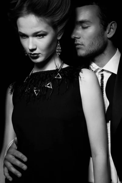 Güzel, tutkulu bir çift koridorda dikiliyor, bir adam bir kadına arkadan sarılıyor.