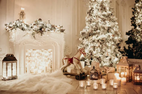 Noel ağacının yanında çelenkleri ve şöminesi olan at oyuncağı