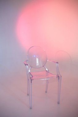 Pembe arka planda izole edilmiş şeffaf sandalye