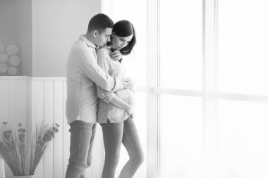 Müstakbel anne babalar aydınlık bir panorama penceresinin arkasında durur.