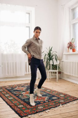 Güzel, çekici ve şık bir kadın evde poz veriyor. 