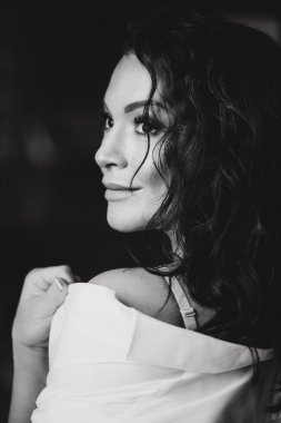 Stüdyoda siyah beyaz poz veren seksi ve çekici genç bir kadın.