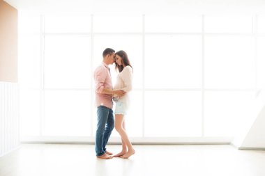 Müstakbel anne babalar aydınlık bir panorama penceresinin arkasında durur.