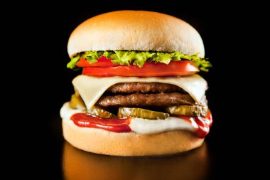  Karanlık arka planda izole edilmiş lezzetli taze hamburger.