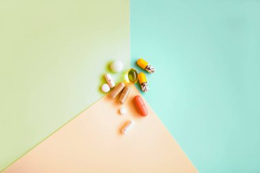 Renkli arka planda farklı hapların ve vitaminlerin üst görünümü