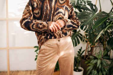 Modern elbiseli şık genç kadın evde poz veriyor.