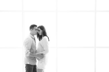 Müstakbel anne babalar aydınlık bir panorama penceresinin arkasında durur.