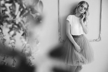 Süslü etek ve bluzla stüdyoda poz veren güzel sarışın manken.