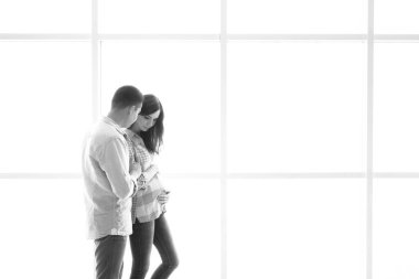 Müstakbel anne babalar aydınlık bir panorama penceresinin arkasında durur.