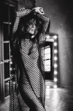 Stüdyoda siyah beyaz poz veren çekici seksi kadın.