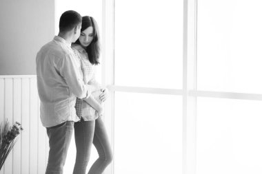 Müstakbel anne babalar aydınlık bir panorama penceresinin arkasında durur.