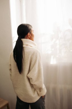 Güzel bir kadın gündüz pencereye bakıyor. 