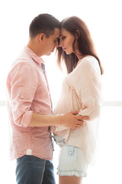 Müstakbel anne babalar aydınlık bir panorama penceresinin arkasında durur.