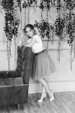 Süslü etek ve bluzla stüdyoda poz veren güzel sarışın manken.