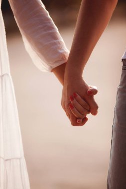 Kumsalda el ele tutuşan çift