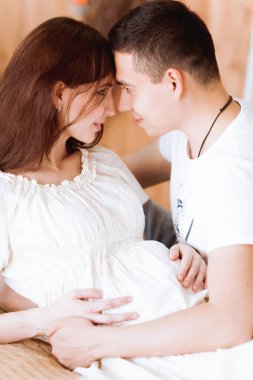 Mutlu ebeveynler yatakta oturup birbirlerine bakıyorlar.