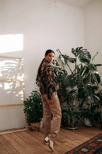 Güzel, çekici ve şık bir kadın evde poz veriyor. 