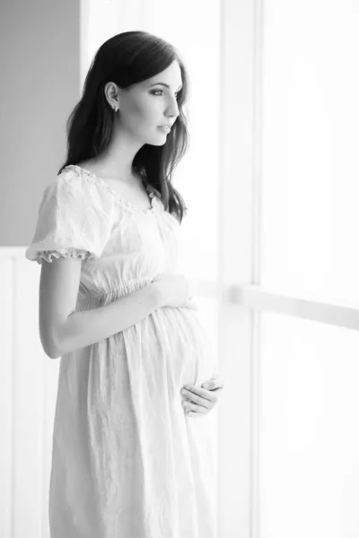 Schöne Schwangere Frau Einem Weißen Kleid Die Fenster Steht — Stockfoto