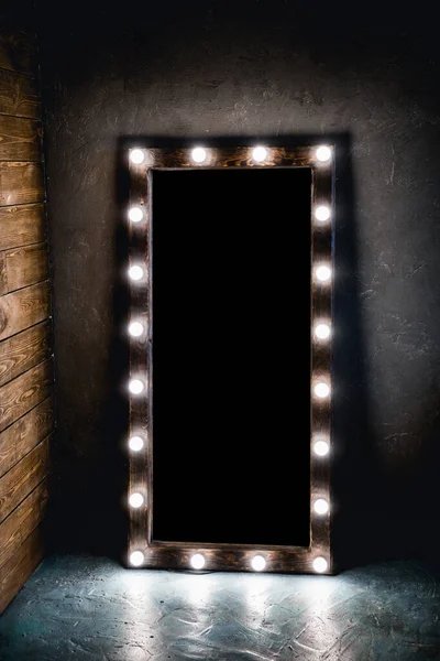 阁楼风格的房间里 一面镜子靠着一堵木制的混凝土墙 地板上立着一面镜子 上面有灯泡 — 图库照片