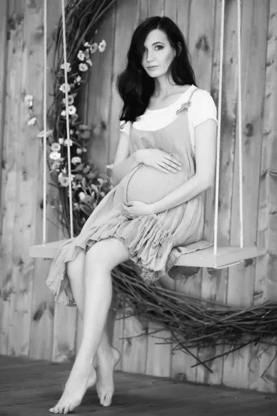 Έγκυος Γυναίκα Κάθεται Μια Κούνια Ξύλινο Φόντο — Φωτογραφία Αρχείου