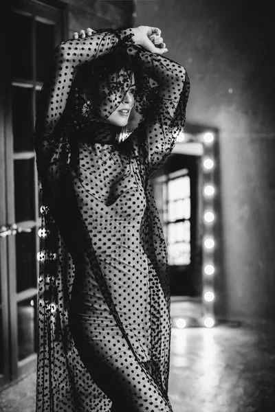 Stüdyoda siyah beyaz poz veren çekici seksi kadın.