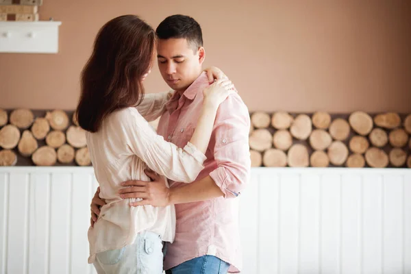 丈夫拥抱着他美丽的怀孕的妻子 幸福的家庭伴侣 有着木制的背景 — 图库照片