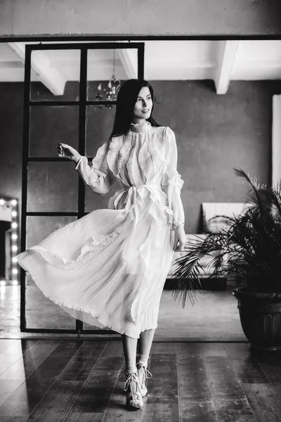 Stüdyoda siyah beyaz poz veren çekici seksi kadın.