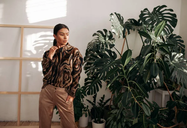 Güzel, çekici ve şık bir kadın evde poz veriyor. 