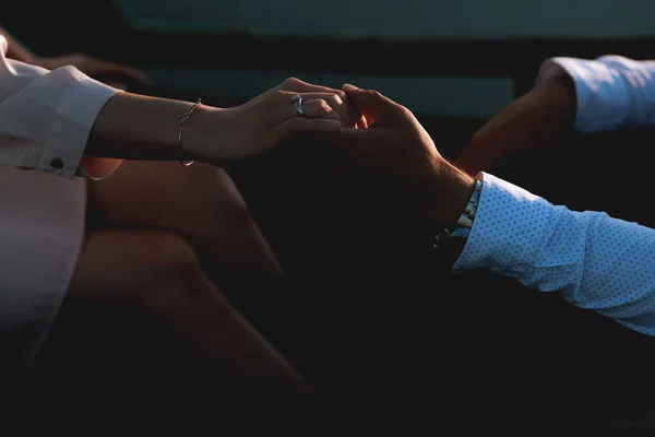 Mutlu genç çift gün batımında el ele tutuşuyorlar.